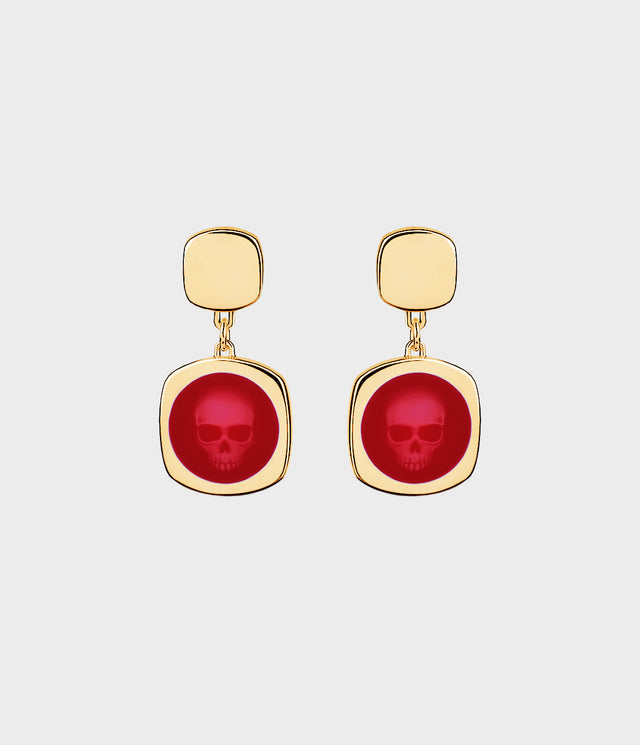 Gold earrings with red enamel featuring skull designs on a white background